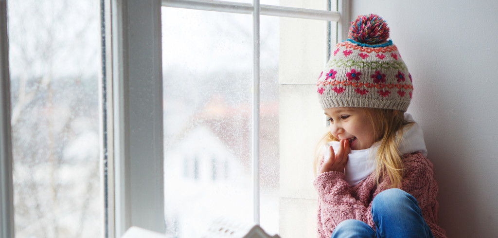little girl on a window sill looks at the street
