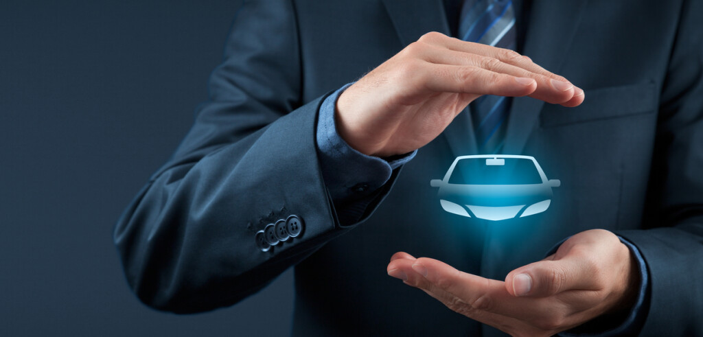 Car (automobile) insurance and collision damage waiver concepts. Businessman with protective gesture and icon of car. Wide banner composition.