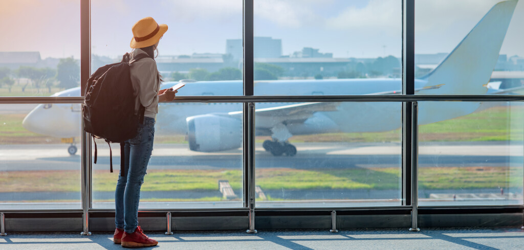 woman passenger tourist or traveller in late, delay checking in the gate terminal at boarding pass entrance, aircraft just leaving from the terminal