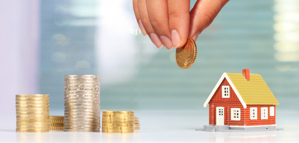 Real estate investment. House and coins on table.