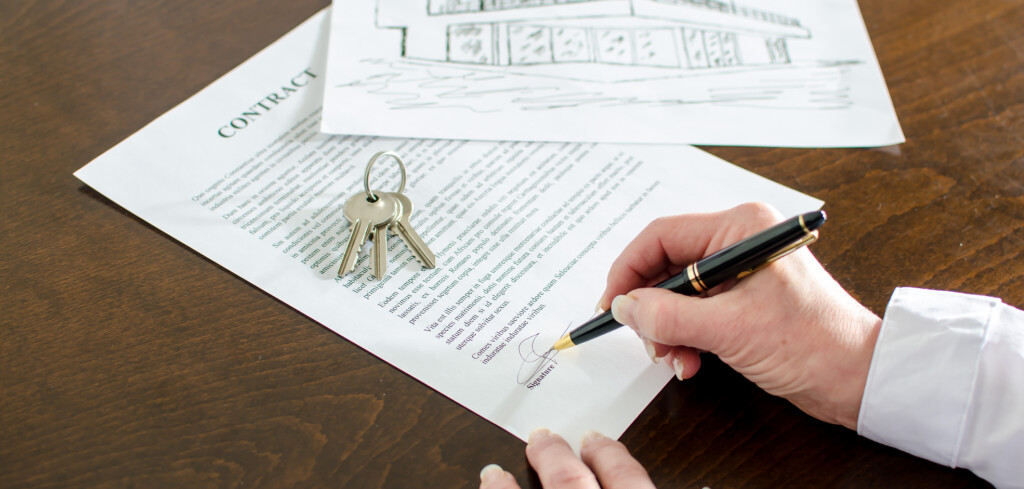 Woman signing a real estate contract on a desk