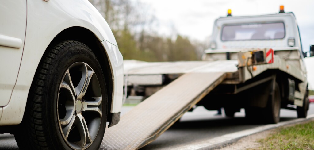 Loading broken car on a tow truck on a roadside