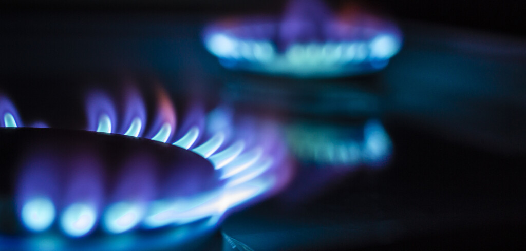 a hundred dollar bill on a gas burner with a burning fire on a black background, the front and back background is blurred with a bokeh effect
