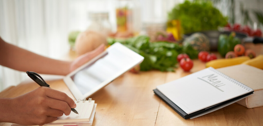 Hands of woman composing healthy menu for upcoming week
