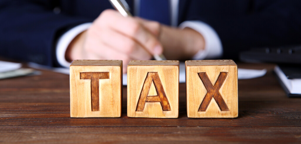 Wooden cubes with word TAX on table